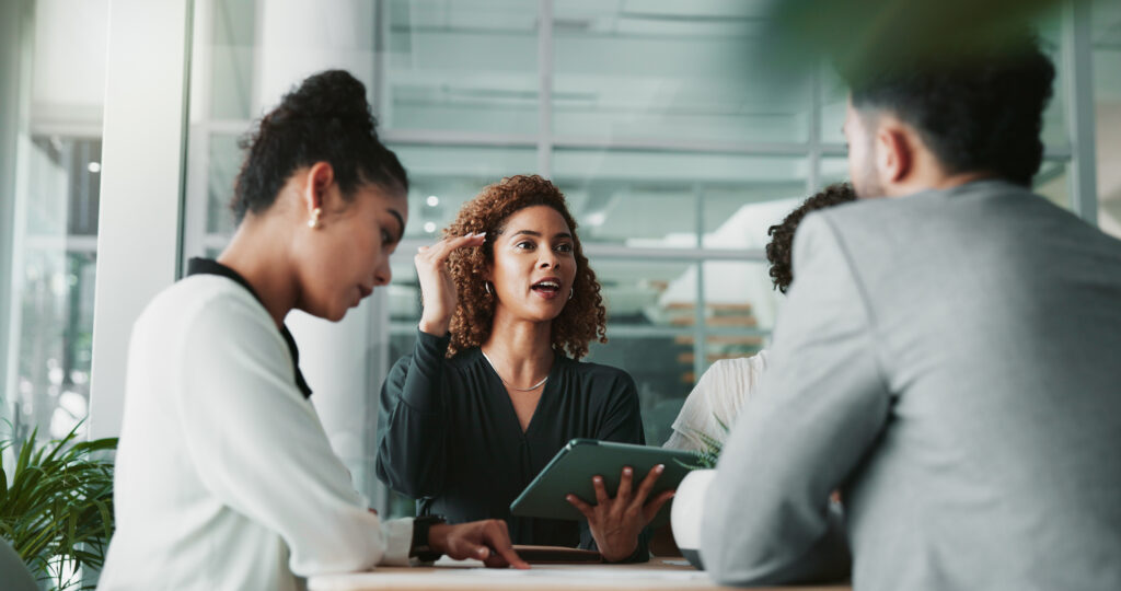Woman, lawyer and tablet at meeting with team, planning and discussion intellectual property renewals. People, attorney and digital touchscreen with group, negotiation and feedback at law firm
